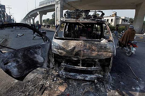 A broadcast van burnt by angry religious party protesters during clash with police