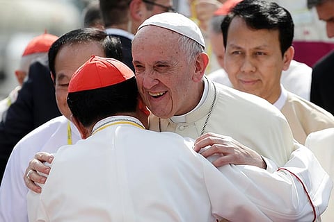 Pope Francis is embraced as he arrives at Yangon International Airport, Myanmar