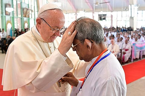 Pope Francis blesses a priest during a meeting with Bangladeshi priests and nuns in Dhaka