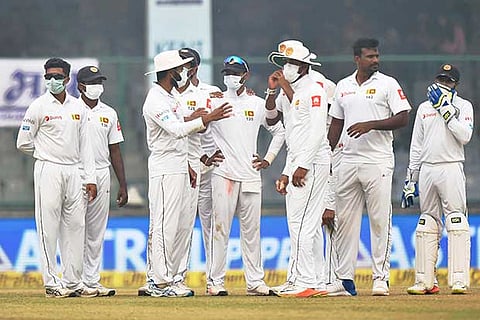 Sri Lankan players wear anti-pollution masks on the field as the air quality deteriorates