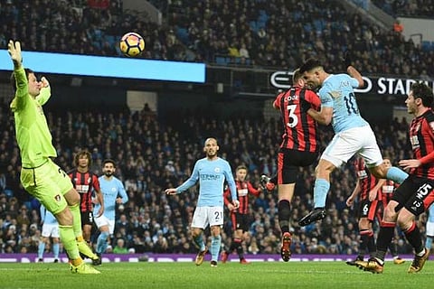 Man City's striker Sergio Aguero (R) heads the ball to score their third goal against Bournemouth
