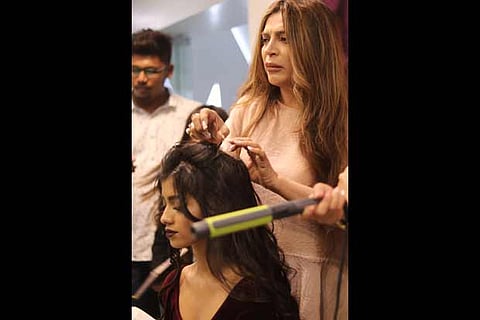 Ojas Rajani fixes a model?s hair during a recent session in the city