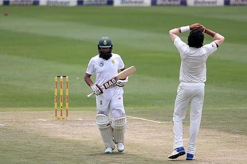 Hashim Amla runs past a dejected Ishant Sharma as the ball heads to the boundary