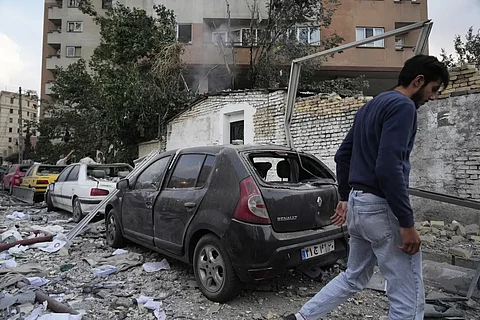 A man walks at the scene of an explosion in a residence compound in northern Tehran, Iran