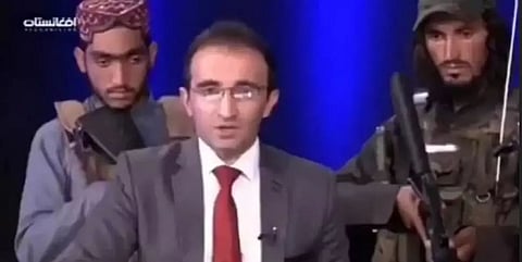 Afghan TV news presenter read out headlines while surrounded by armed Taliban
