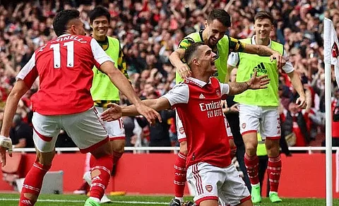 Arsenal down 10-men Tottenham to stay top