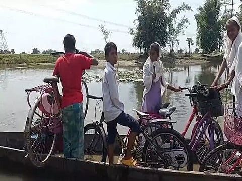 Assam: Students from Sila Mari village cross stream on makeshift boat to reach school