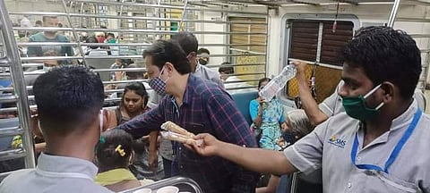 दादर रेल्वे स्थानकात थांबलेल्या लोकल मधील प्रवाशांना मदत करतांना रेल्वे कॅटरिंग कर्मचारी