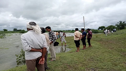 जवळगाव (ता.अंबाजोगाई, जि.बीड) : मुरंबी लघुसिंचन प्रकल्पाच्या सांडव्यात बेपत्ता युवकाचा शोध घेताना ग्रामस्थ.