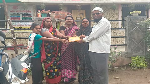 ढाकेफळ (ता.पैठण, जि.औरंगाबाद) : पोस्टाद्वारे आलेल्या राख्याचे पाकिट एका कुंटूबाला देताना पोस्टमन रऊफभाई शेख. (छायाचित्र ज्ञानेश्वर बोरूडे)