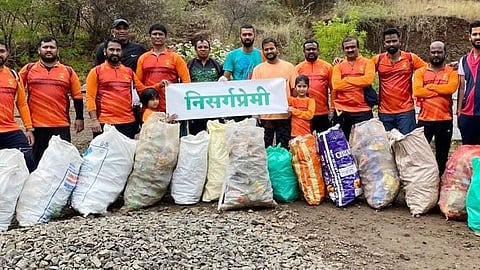 कानिफनाथ गडावरील कचऱा स्वच्छ करून पोत्यात जमा केलेल्या कचऱ्यासमवेत निसर्गप्रेमीं