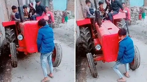 small child lifted the tractor with his hands
