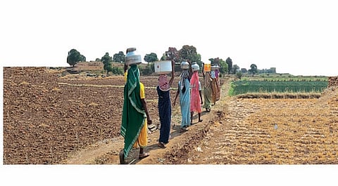 डोक्यावर पाणी घेवून जाताना महिला.