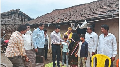 Tehsildar Aba Mahajan handing over a check to Bhangi Pavara's wife.