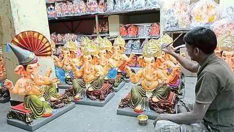 Sculptors putting final touches on finished Ganesha idols.