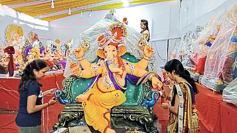 woman decorates large idol sold with colorful gems as the demand for large idols increases.
