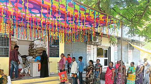 Ration shopkeepers welcoming ration card holders by drawing rangoli and distributing rations