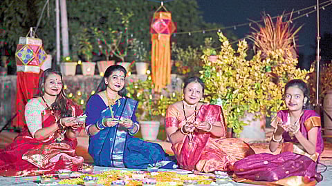 rangolis are drawn in the courtyards and lanterns are lit. Women celebrating Diwali