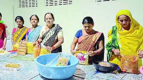 Women of Sanskriti Gram Sabha Savings Group packing snacks.