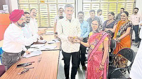 Malgegaon Civil District Judge Tejwantsinh Sandhu giving flowers to the couple at the district court to marry them. A lawyer next door.