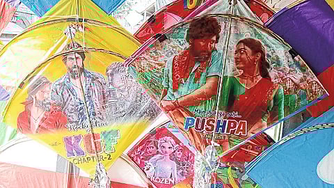 Kites for sale in a market with scenes from a South Indian film.