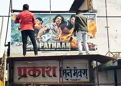 Bajrang Dal activists tearing down Pathan posters at Prakash Theatre
