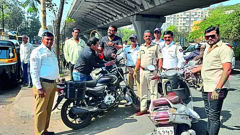Employees of the city transport department putting 'anti-manja tar' on two-wheelers