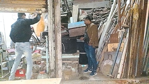 Police officers, employees inspecting the stolen utensils.