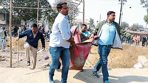 Jalgaon: Police personnel carrying the burnt body found in front of the police station in the industrial estate area