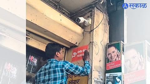 Ongoing work of Bhadrakali police to put up police camera stickers on shops in the market
