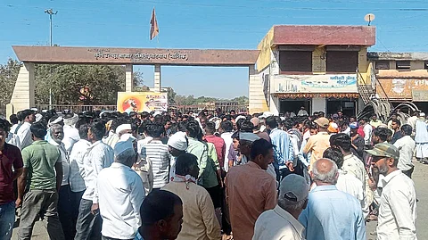 Farmers participating in the protest in front of the entrance of the market committee.