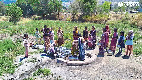Women waiting for hours with empty water bottles in front of the only hand pump in the village to get a full water bottle