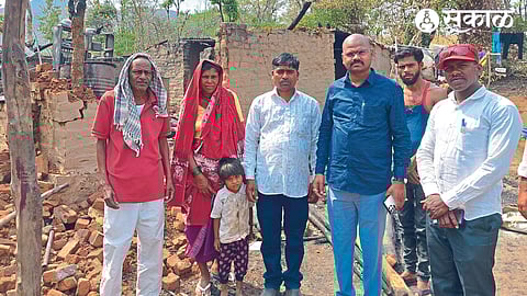 Vaman Khoskar inspecting the fire damage to Bhau Pardhi's house.