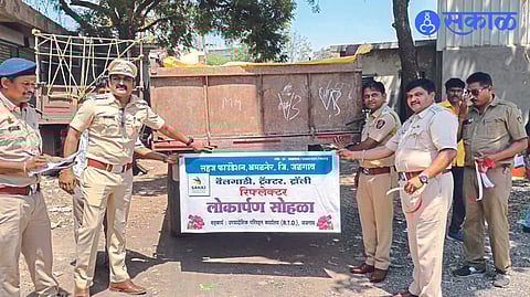 Transport officer at RTO office attaching reflector to tractor trolley. Along with DySP Rakesh Jadhav and others.