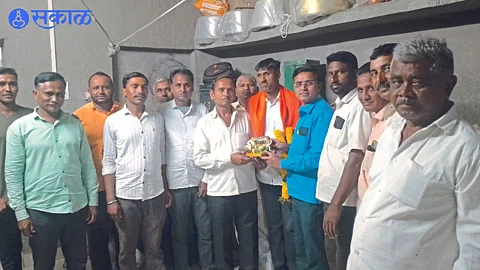 Gokul Bedse, Dinesh Thackeray and villagers felicitating Chandrakant Patil, who overcame blindness and got a job in the railways.