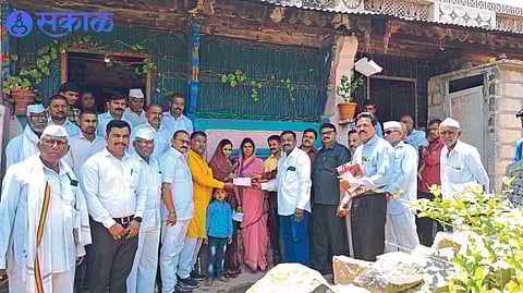 Social activist Nimba Marathe giving a check to the family of Kalamkar who died due to electric shock