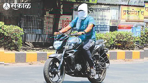 A biker with a handkerchief tied around his mouth as the heat increases