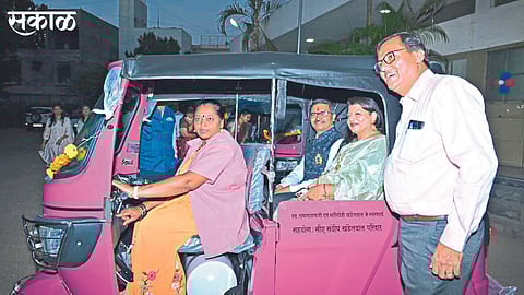 Passengers taking a ride in a pink rickshaw that has entered service.