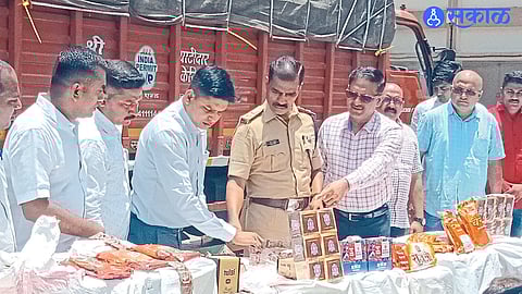 Dhule: Superintendent of Police Sanjay Barkund inspecting the seized gutkha. Other officers and teams nearby.