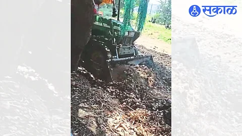 Yogesh Patil burying damaged onion in chali in a pit with the help of tractor beam.