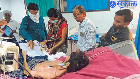 Dhule: Revenue staff taking patient's signature on land acquisition compensation documents at Jawahar Hospital.