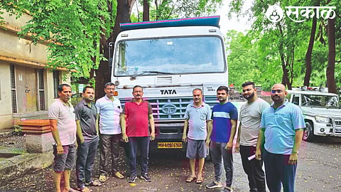A revenue team member with a dumper full of seized sand