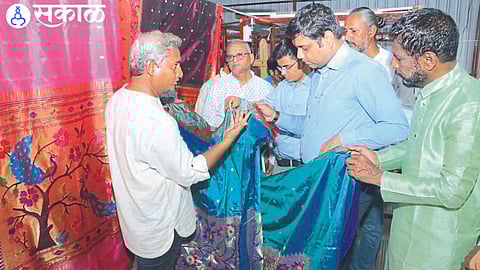 District Collector Aman Mittal while inspecting the Paithani prepared in the factory. Neighboring officers and factory directors.