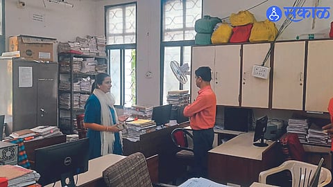 Mrs. Mittal looking at the bundles of files in the departments.