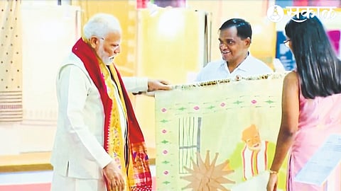 Narendra Modi watching his replica of Prime Minister Modi being woven on the charkha at Paithani Shela.