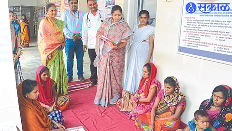 State Women's Commission member Deepika Chavan, medical officer next to her while discussing with a female patient who came to the primary health center.