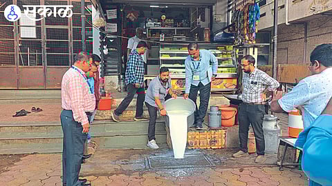Vendor pouring adulterated milk after inspection by authorities.
