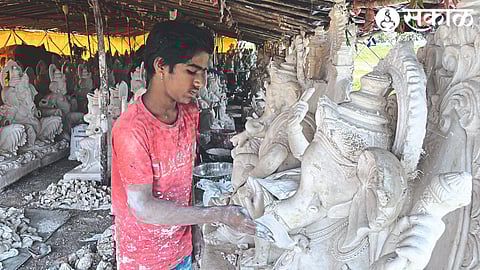 Sculptor painting Ganesha idols.