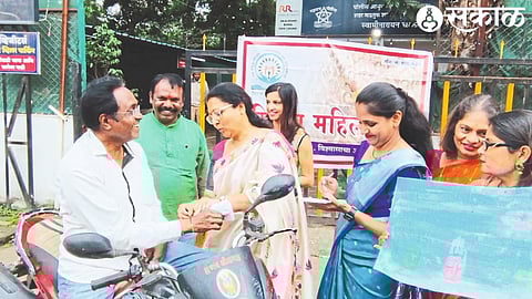While tying rakhi to the drivers without helmet, Dr. Ashwini Boraste. Neighbor Suresh Pawar, Mahila Manch office bearer, member.