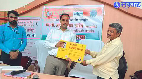 Collector Ayush Prasad giving certificates to the beneficiaries regarding self-funding. Neighbor Administrator Ravindra Lande.